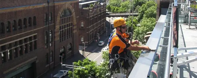 At the roof edge, Rigging above a city street.