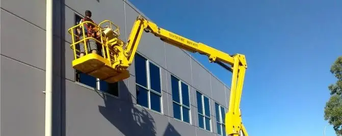 Boom lift at a facade, Worker in the basket at the windows.