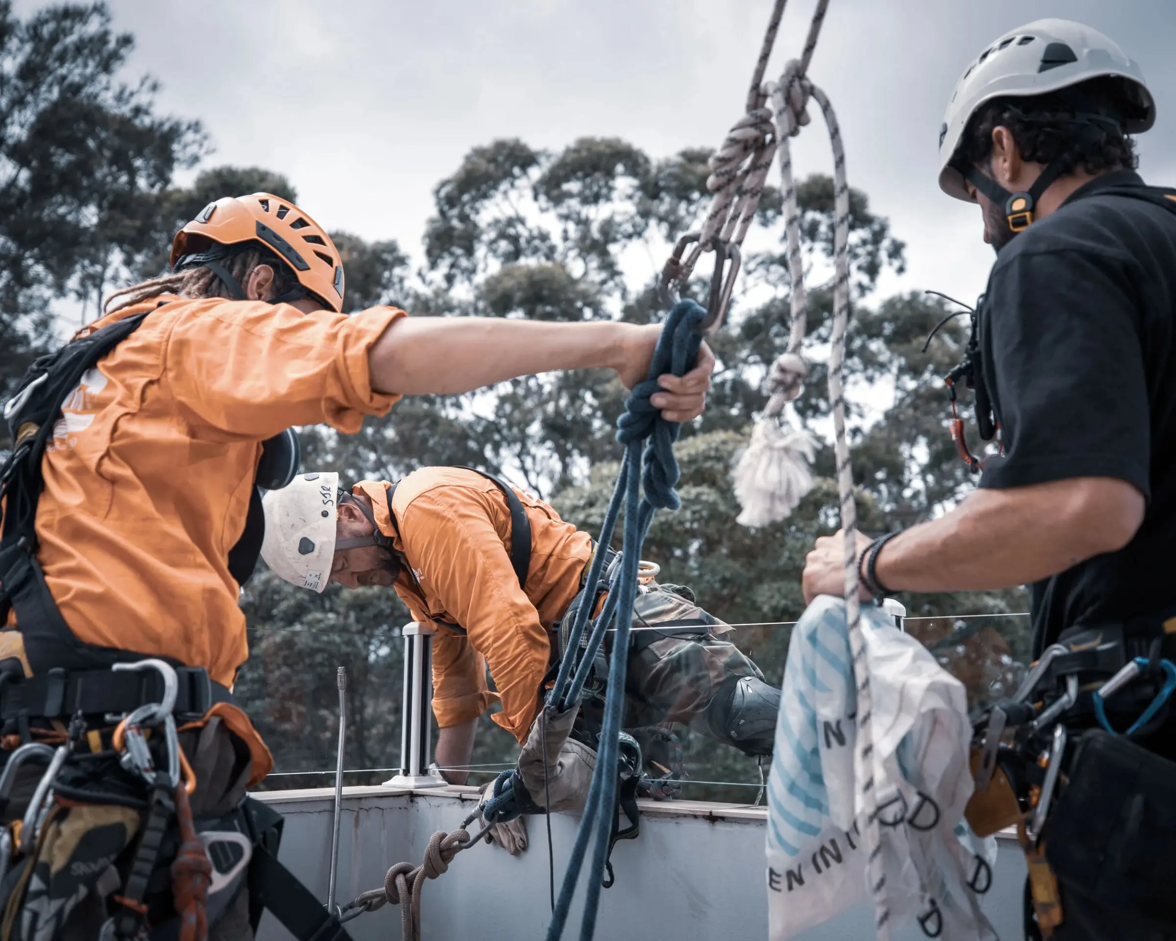 Three rope access technicians going over the roof edge, Wolseley Rd, Lindfield