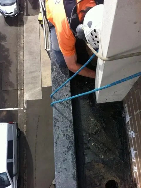 Grinding on ropes to prepare for waterproofing, Brooklyn, Cornwallis St · planter boxes