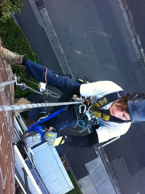 Cleaning out weep holes on ropes, Brooklyn, Cornwallis St · brickwork