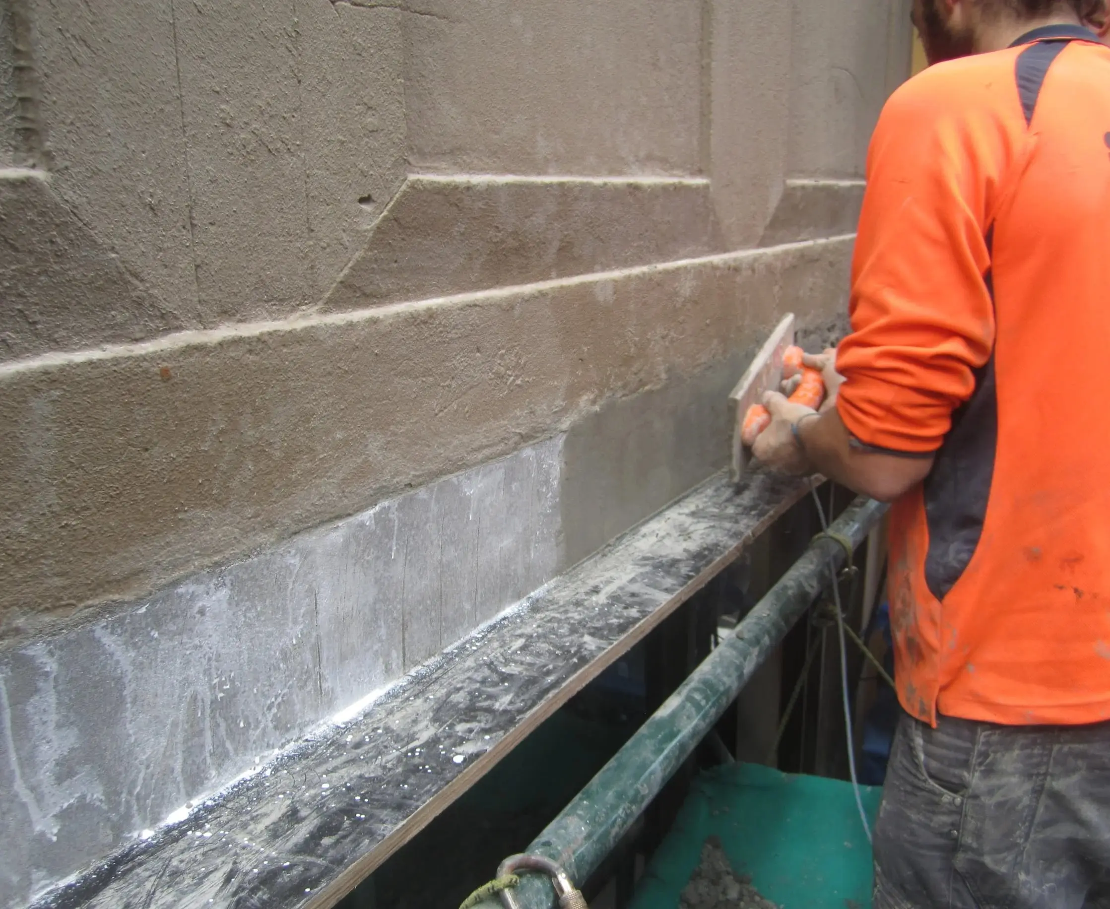 Finishing the repair, A technician trowelling the reinstated section of the beam smooth.
