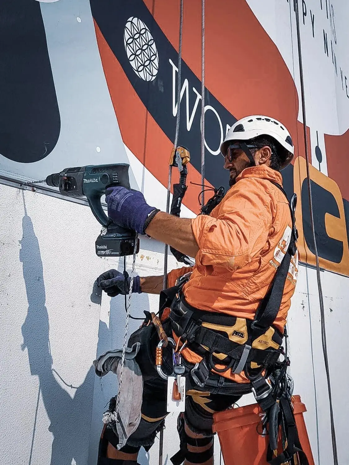 Drilling on ropes beside a large building sign, Crew photo shoot, 2020
