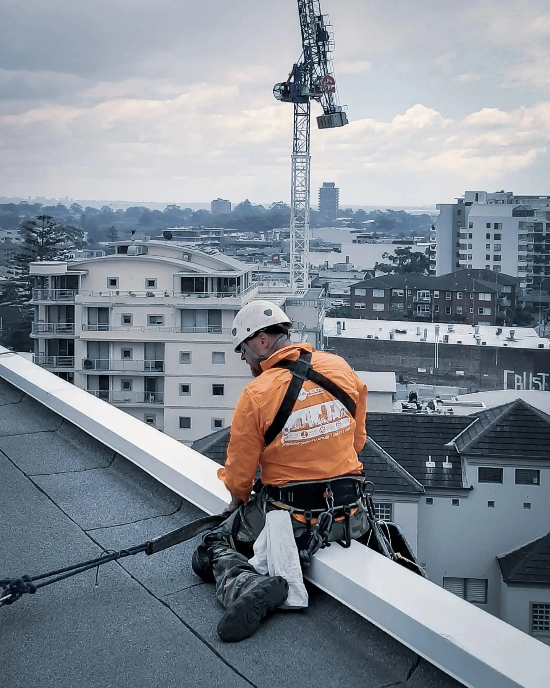 Technician at the roof edge, city and crane behind, Crew photo shoot, 2020