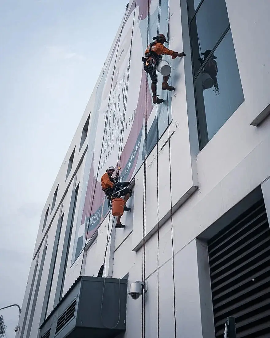 Two technicians on ropes down a tall facade, Crew photo shoot, 2020