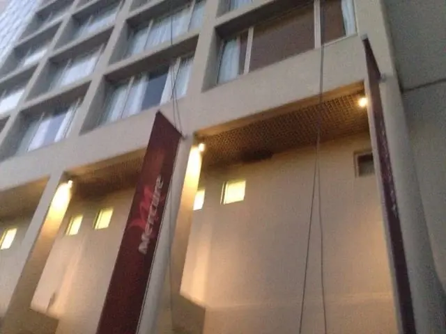 Facade uplights, Warm lights washing up the facade columns between Mercure banners at dusk.