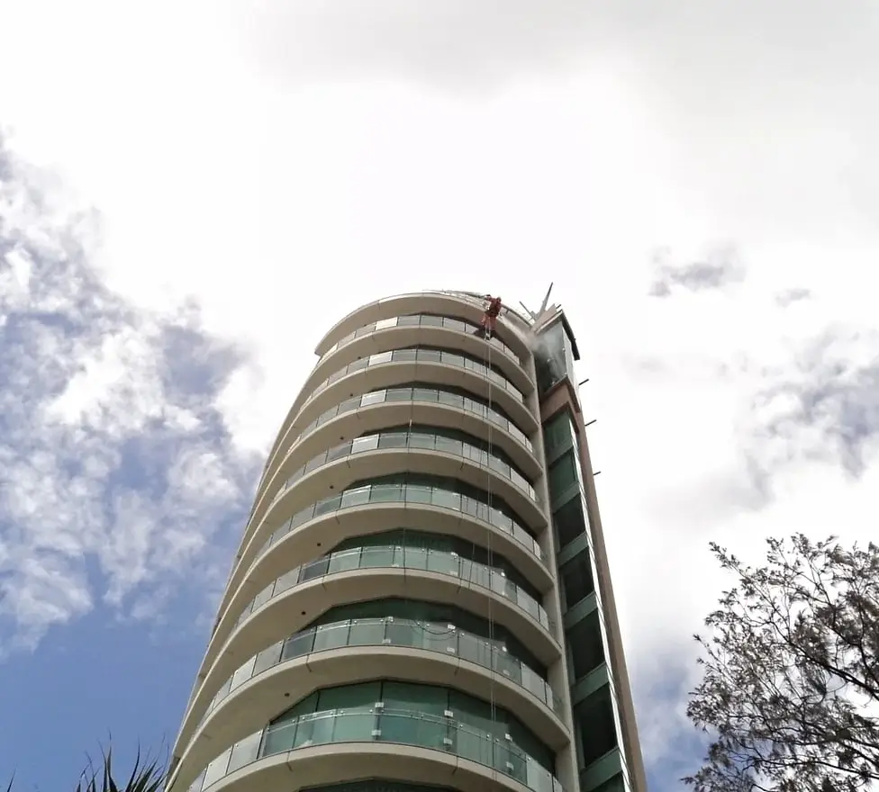 Jade Apartments, A technician on ropes at the top of the curved tower.