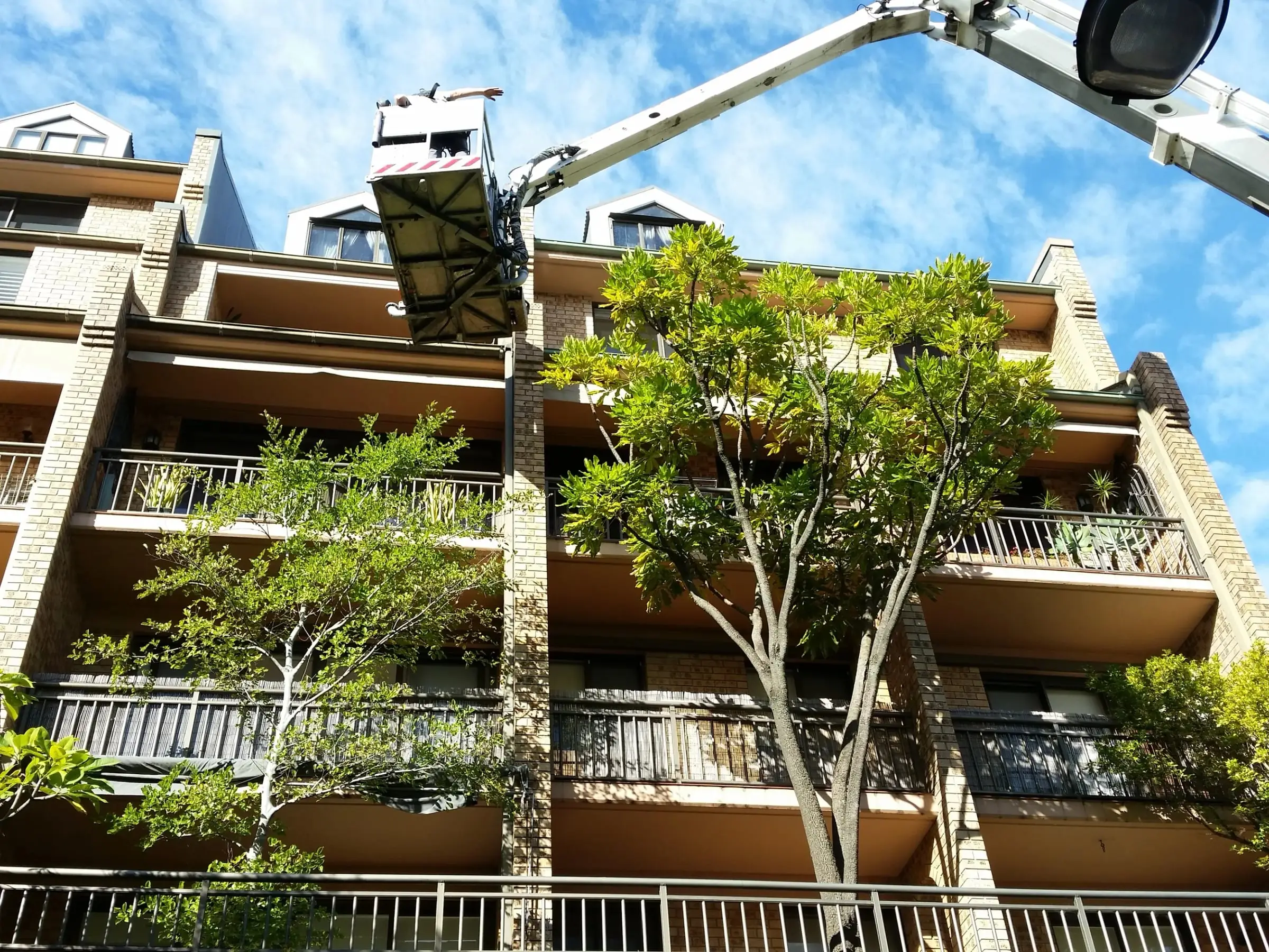 Elevated work platform, An elevated work platform raised to the roof line of a brick apartment building.