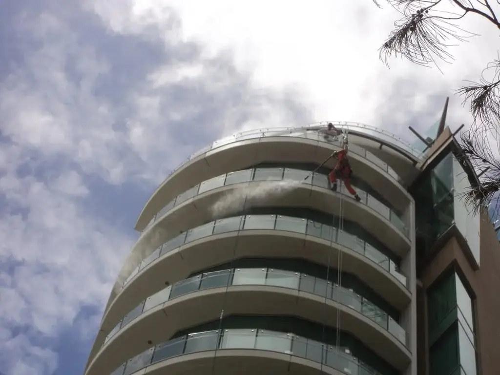 Pressure washing the curved facade on ropes, Jade Apartments · 2011–12