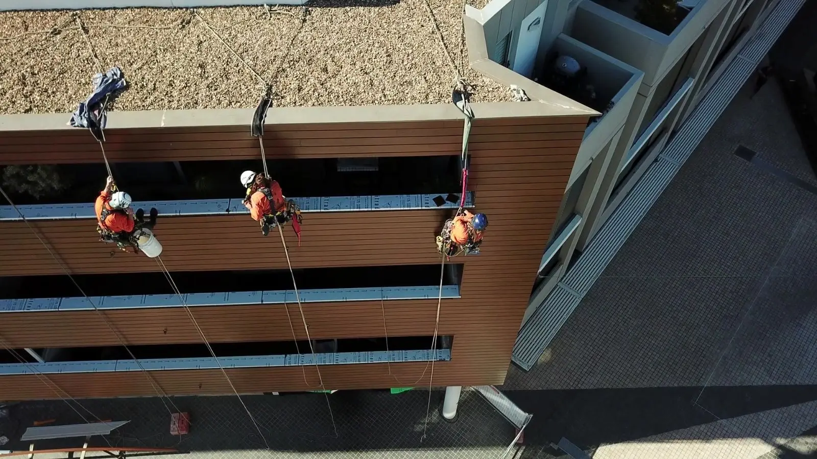 Drone view of OneVision rope access technicians replacing cladding at Cammeray Square