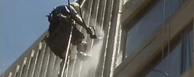 Facade wash, A technician on ropes washing a ribbed facade.