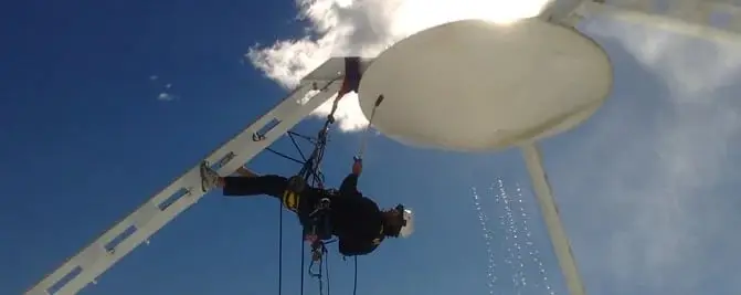 Washing a dish, A roped technician spraying the underside of a dish.