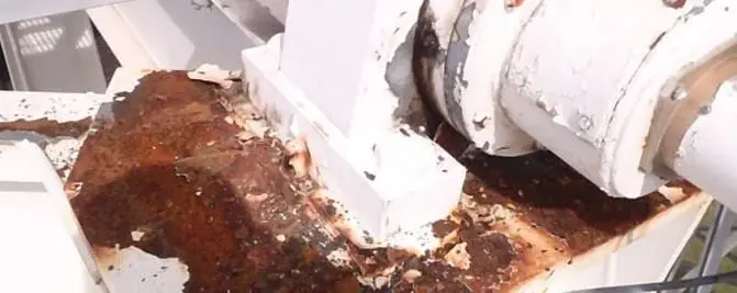 Corrosion at a steel joint, Heavy rust and peeling paint around a bolted steel joint before treatment.