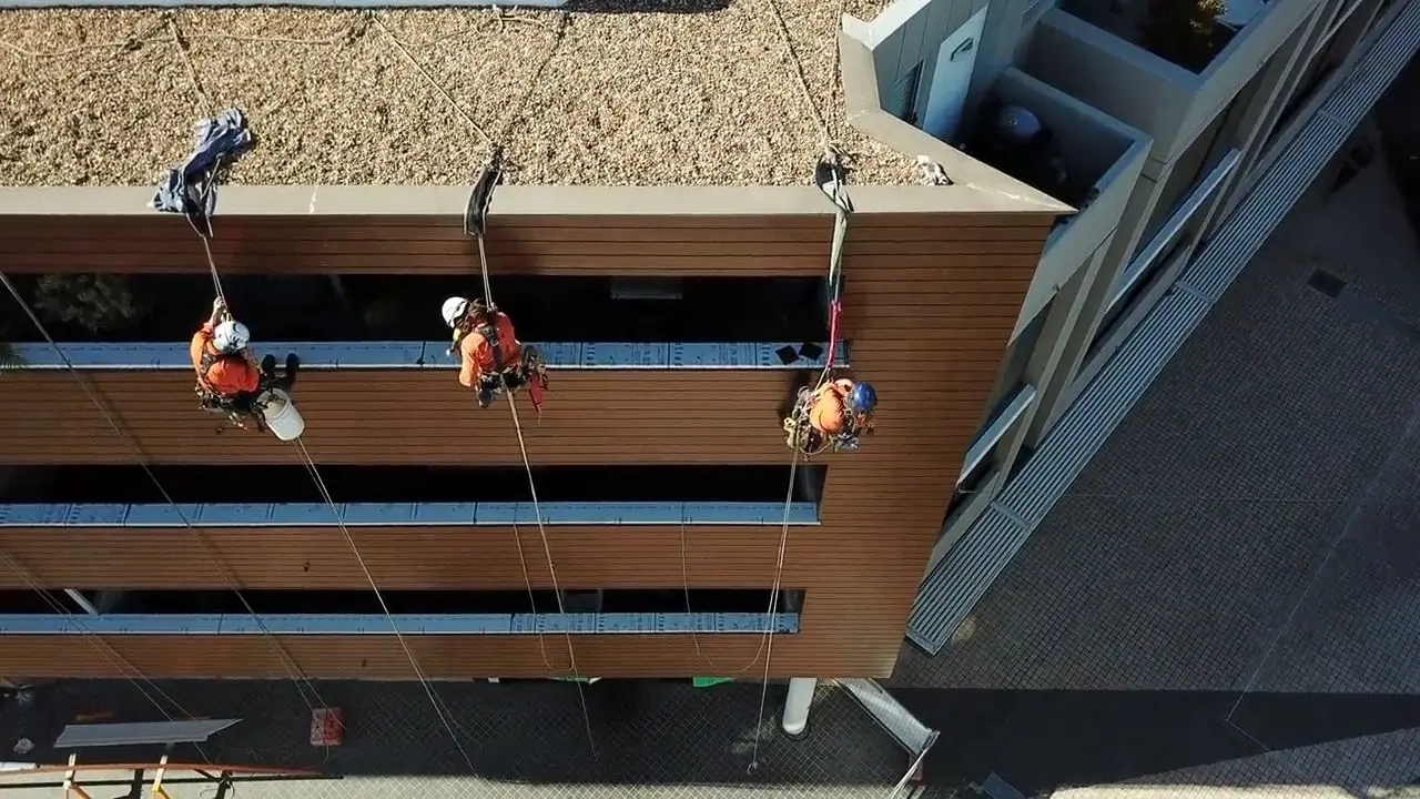 Video: Four technicians on the facade, Top-down drone