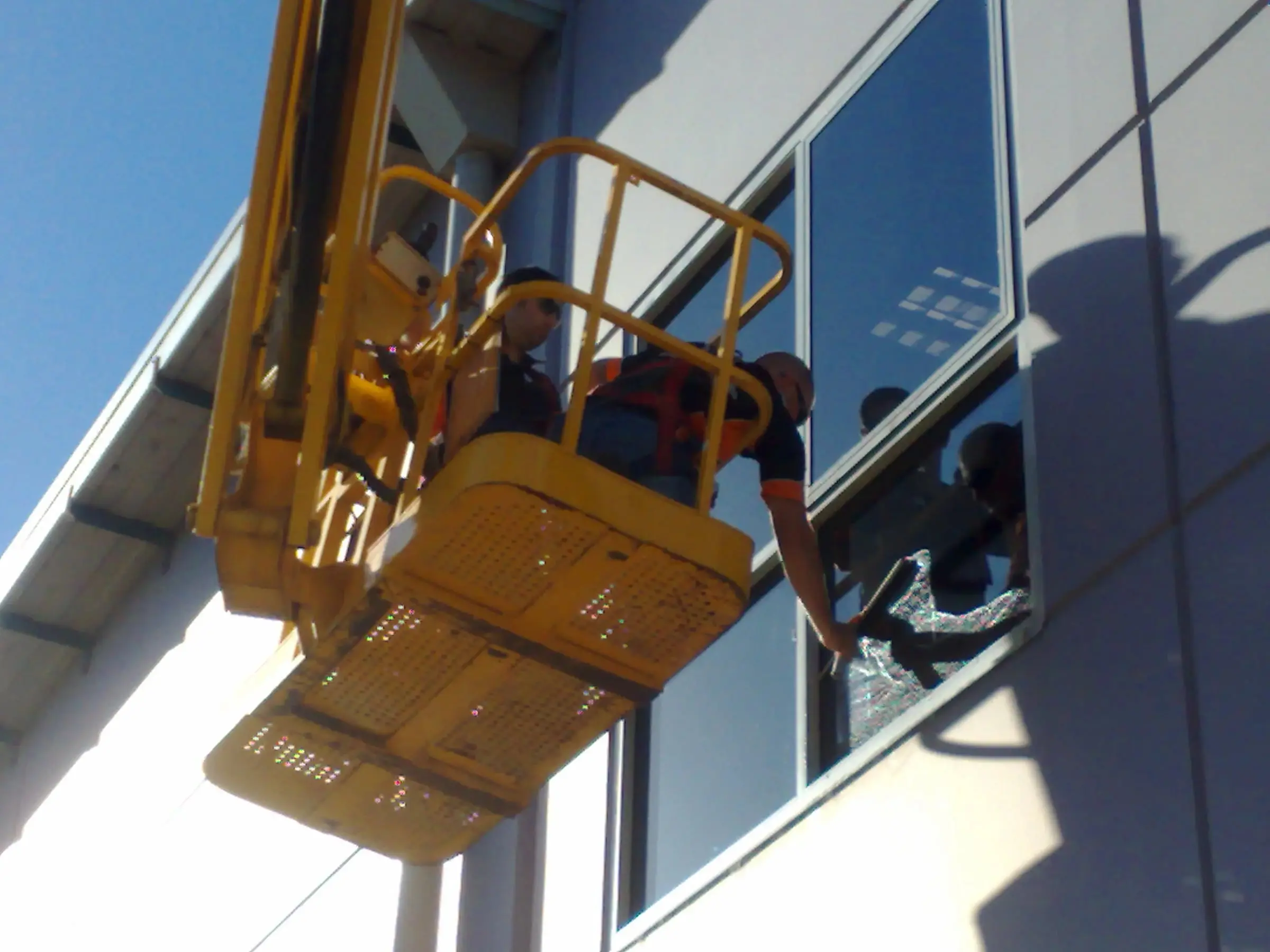 Boom lift access, Two technicians in a boom lift basket at an office window.