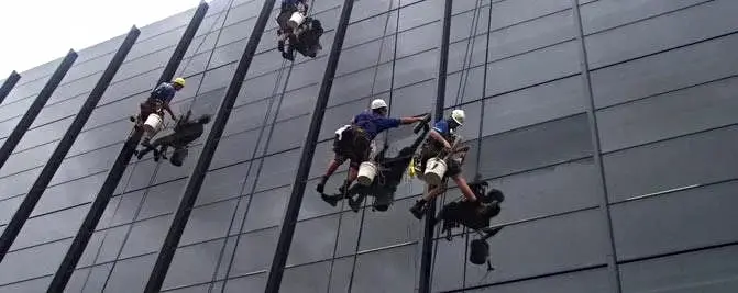 High-rise glass, Four technicians on ropes across a glass facade.