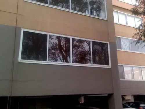 The window, A long four-pane window on a rendered facade.