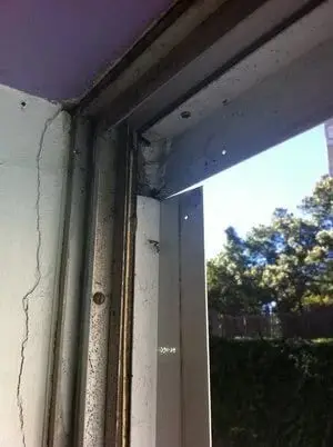 Frame corner, A cracked wall beside a worn window frame.